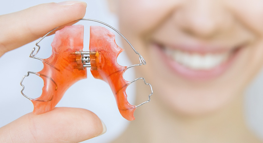 Puntillo and Crane Orthodontics, Palatal Expander, Person holding up a palatal expander